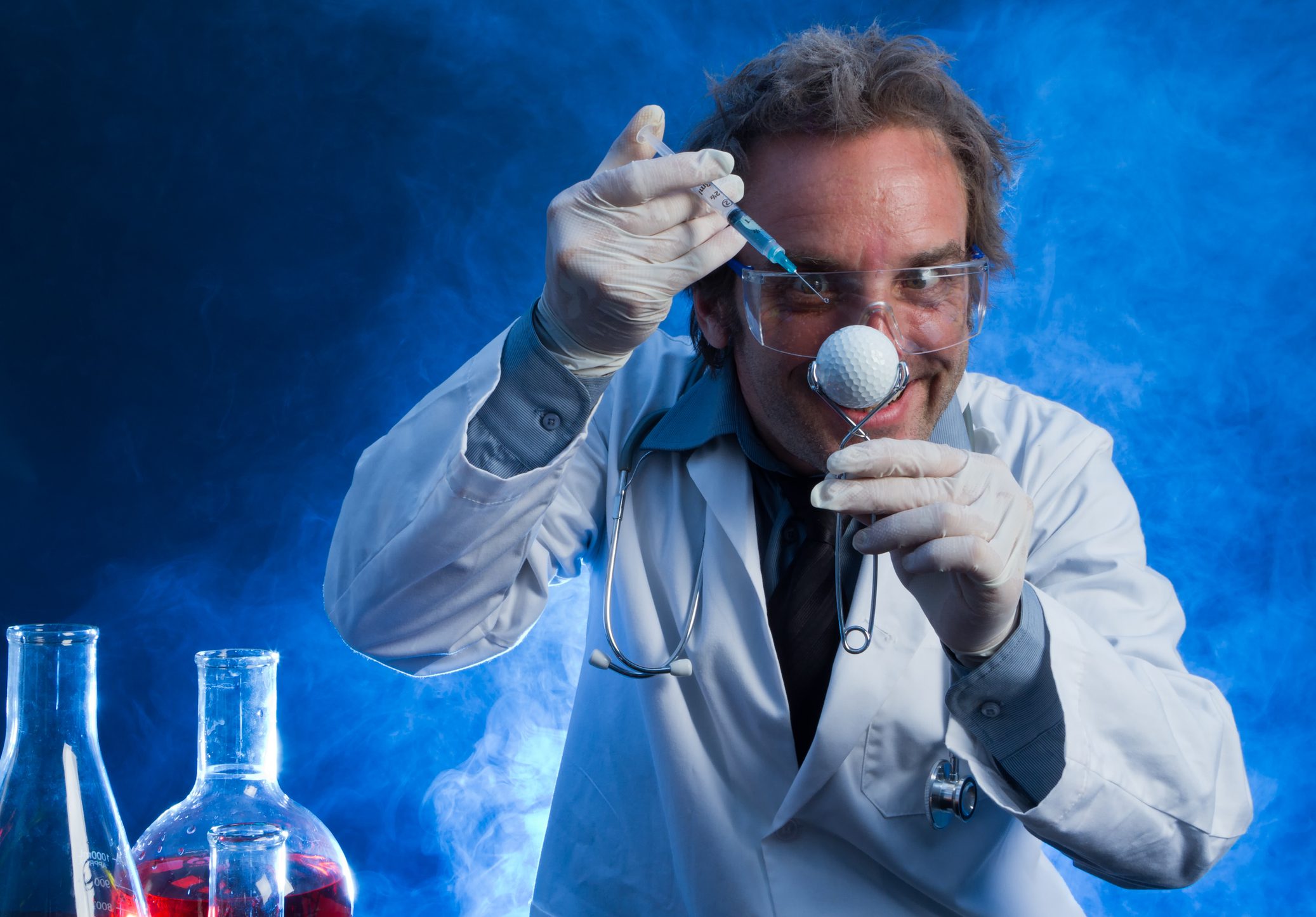 A mad scientist uses a hypodermic needle during an experiment to improve a golf ball